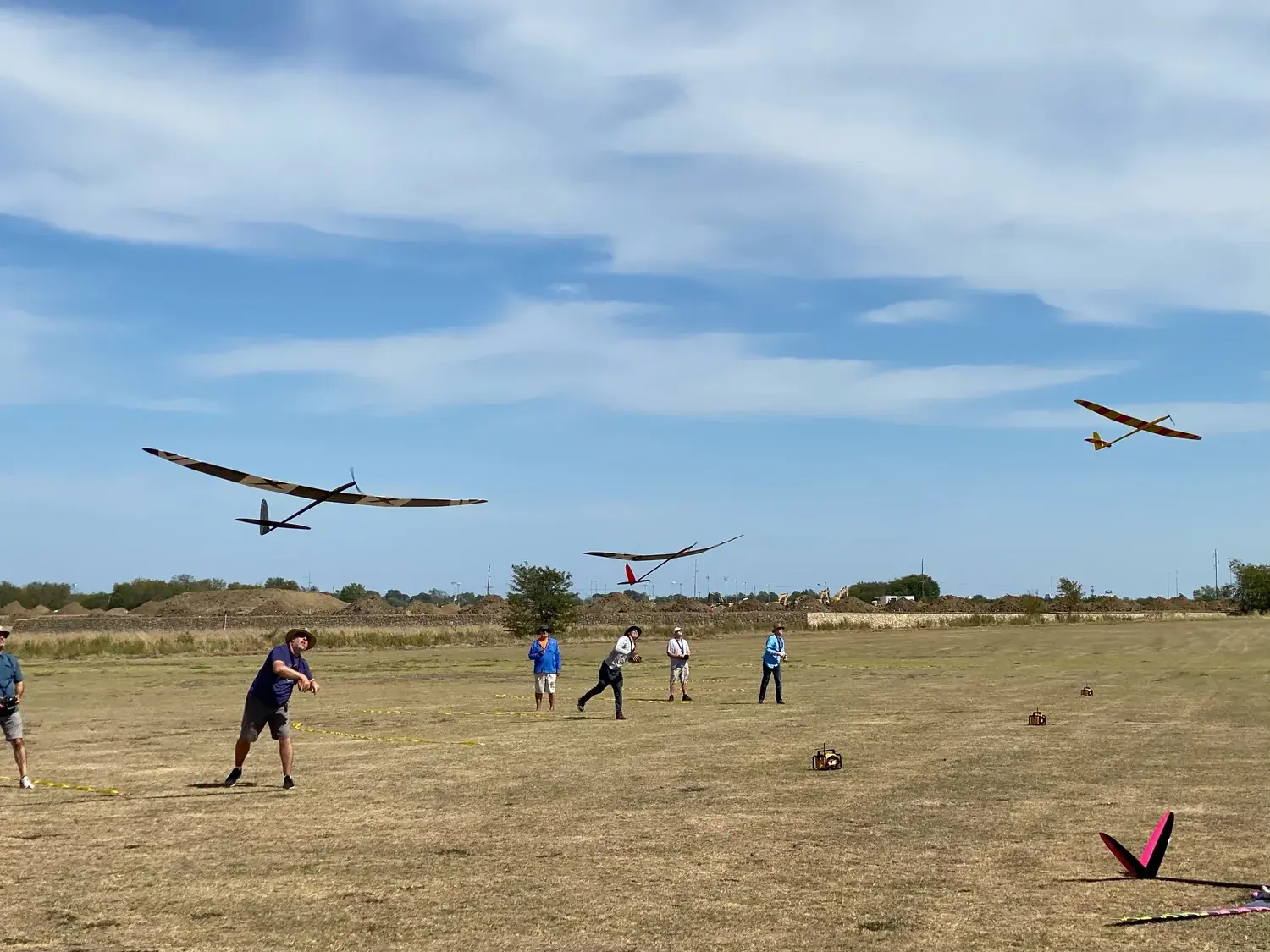 Sailplanes and pilots on the field during a contest day